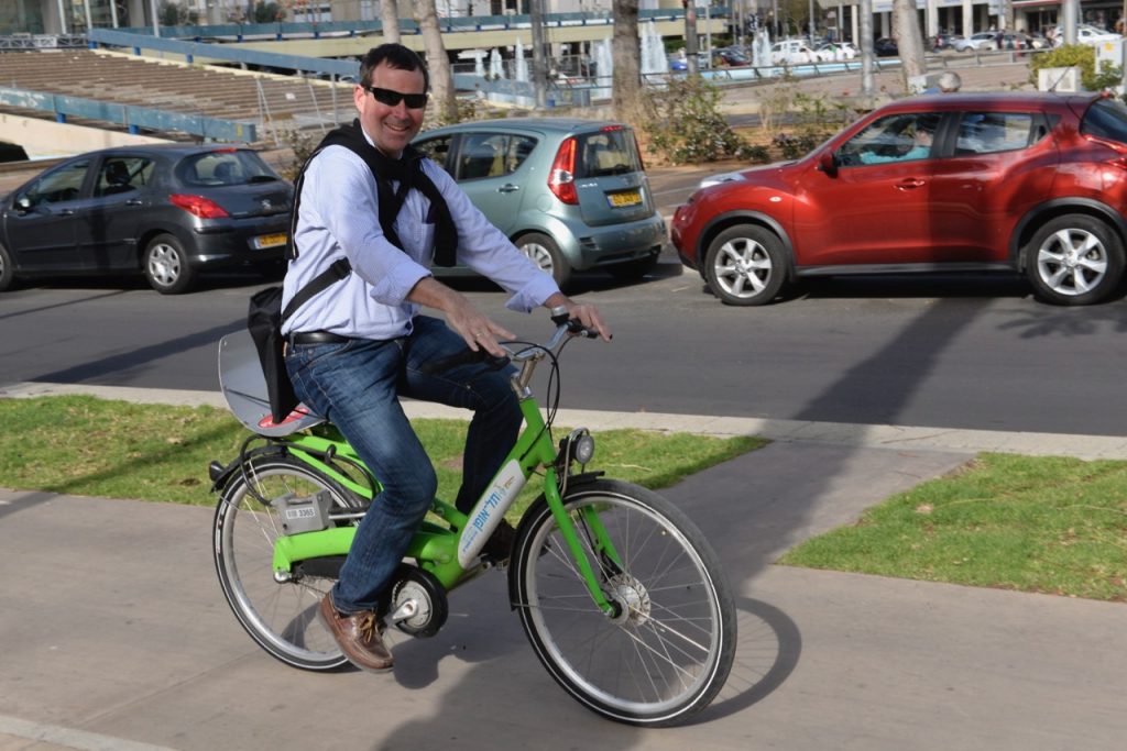 Photo of Andrew Nash riding shared bike in Tel Aviv - Yafo.