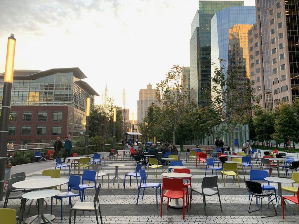 Photo of SF Salesforce Transit Center rooftop park showing cafe chairs and buildings..